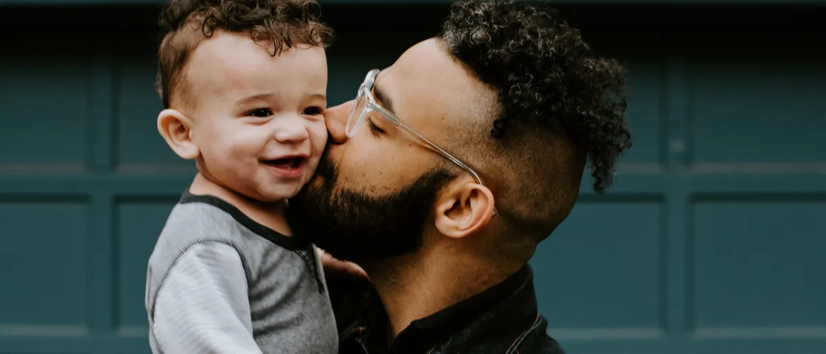 Father kissing son on cheek