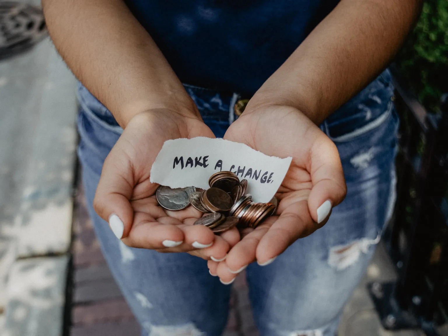 Hands held forward with change and a small written note that says "make a change"