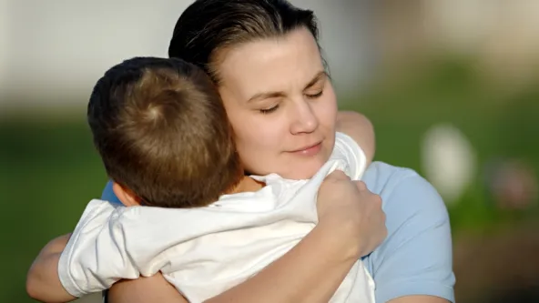 A mom hugs her son 